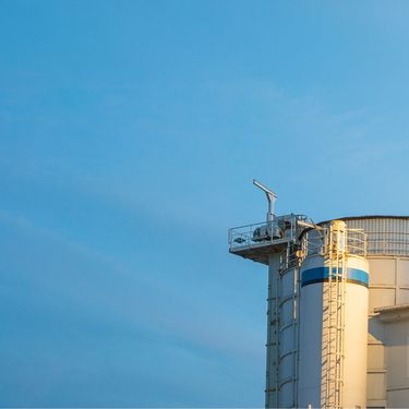 dunkelblauer Abendhimmel mit einer blau-weißen Wasserstoffaufbereitungsanlage
